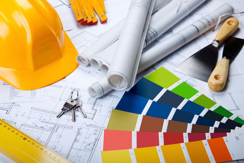 Hard hat, architectural drawings and finish swatches laid out for a retail build project